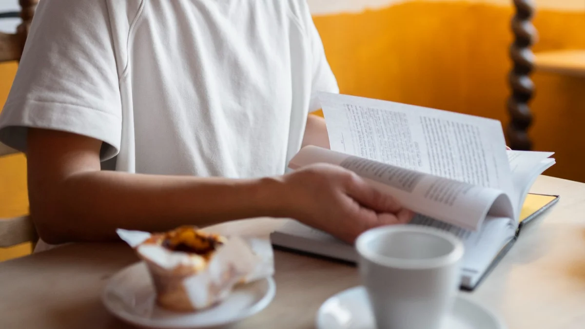 Woman sitting at table flipping through pages of a book